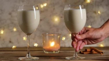 Eggnog bardağını koyan kadın eli. Noel içkisi..