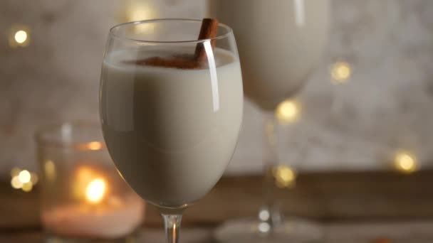 Christmas eggnog drinks with cinnamon with blinking decorative light . — Stockvideo