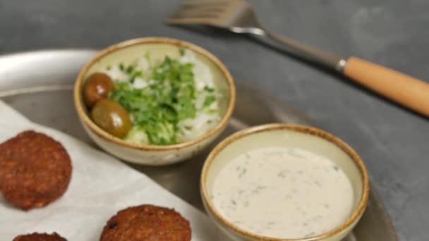 Falafel en plato con tahini y ensalada de col. Falafel sobre papel blanco . — Vídeos de Stock