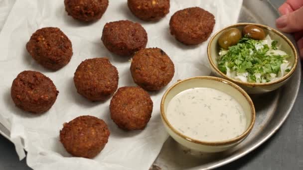 Falafel on plate with tahini and cabbage salad. Falafel on white paper. — ストック動画