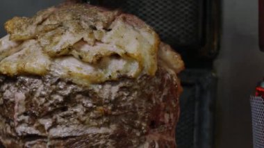 Shawarma pişirmek için bir makine, şişe asılmış et katmanları. Sokak yemeği. .