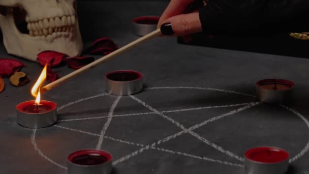 Frau zündet rote Kerzen an. Magisches Ritual mit okkulten Symbolen. — Stockvideo