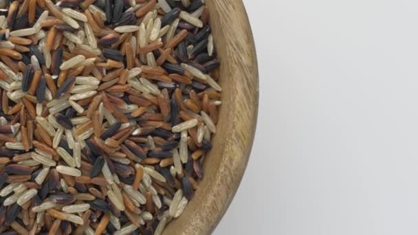 Arroz integral, arroz jazmín negro y baya de arroz en un tazón de madera . — Vídeos de Stock