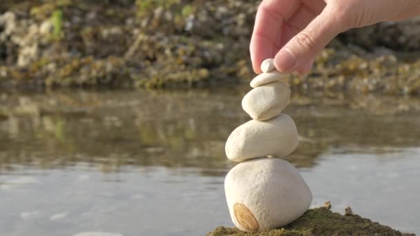 Χέρι βάζοντας την τελευταία πέτρα. Έννοια της ισορροπίας και της αρμονίας. — Αρχείο Βίντεο