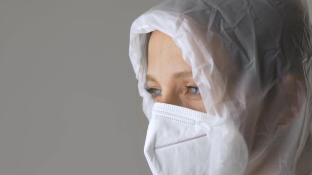 Vrouw doet een beschermend pak en masker af. Close-up — Stockvideo