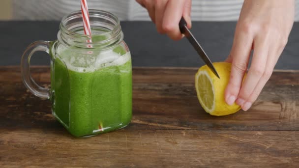 Žena zdobení sklenice zdravého zeleného smoothie — Stock video
