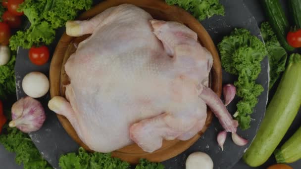 Сырая курица с овощами на деревянной тарелке — стоковое видео