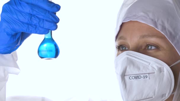 Cinemagraph. Doctor wearing highly protective suit and examining a test tube. — Stock Video