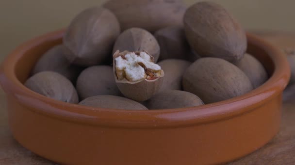 Roterande pekannötter på ett träbord — Stockvideo