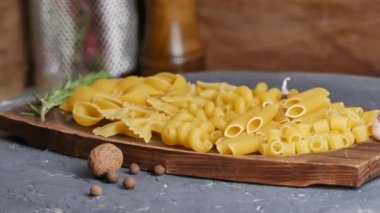 Tahta tabakta çeşitli makarnalar. Döndürme. 