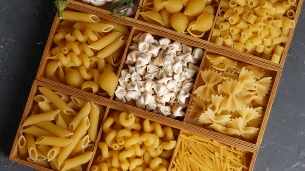 En låda som roterar fylld med olika typer av rå pasta. — Stockvideo