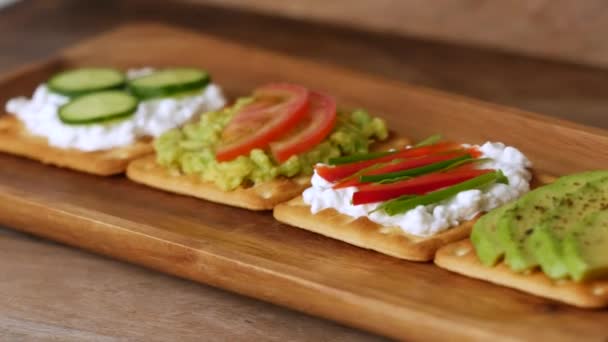 Collation saine avec fromage et légumes sur fond de bois . — Video