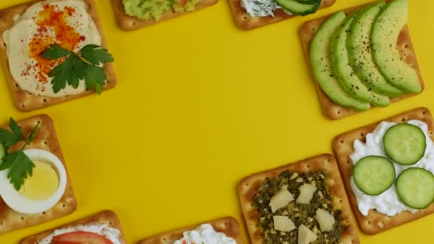 노란색 배경 위에서 돌아가는 치즈와 야채로 만든 건강에 좋은 간식. — 비디오