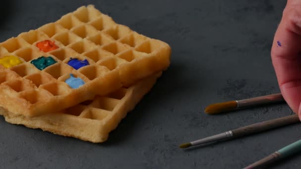 Een borstel dompelen in een gekleurde Belgische wafel. — Stockvideo