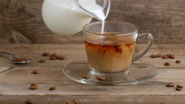 Taza de café y granos de café. Verter leche en el café . — Vídeo de stock
