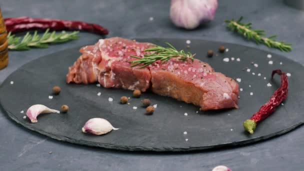 Tender beef sirloin on stone board with coarse sea salt, pepper and rosemary. — Stock Video