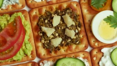 Peynir soslu lezzetli krakerler, humus, avokado, pesto ve sebze..