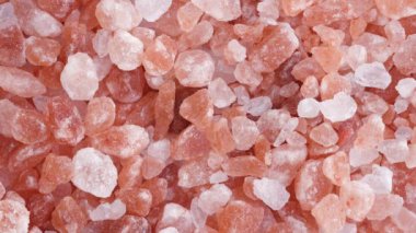 Himalaya tuzunun dönen makro görüntüsü masaya düşüyor..