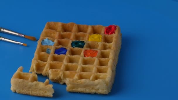 Girando waffles belgas de cor doce em um fundo azul . — Vídeo de Stock