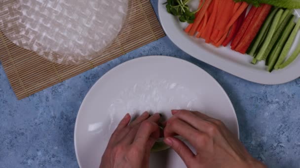 Het proces van het koken van veerrollen - vrouwen handen zetten rollende veerrol. — Stockvideo