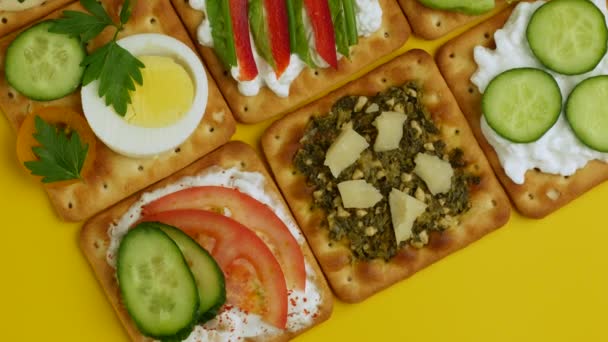 Collation santé avec fromage et légumes tournant sur fond jaune . — Video