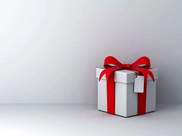 Caja de regalo con lazo de cinta roja y etiqueta en blanco sobre fondo de pared blanco con sombra abstracta —  Fotos de Stock