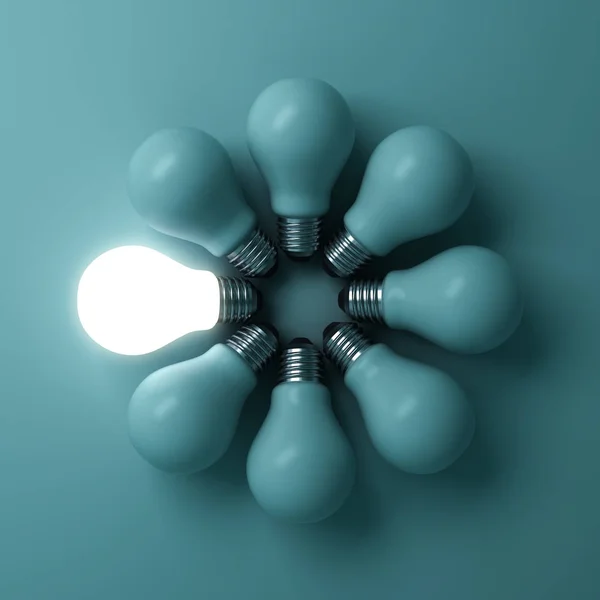 One glowing light bulb standing out from the unlit incandescent bulbs on green background with shadow — Stock Photo, Image