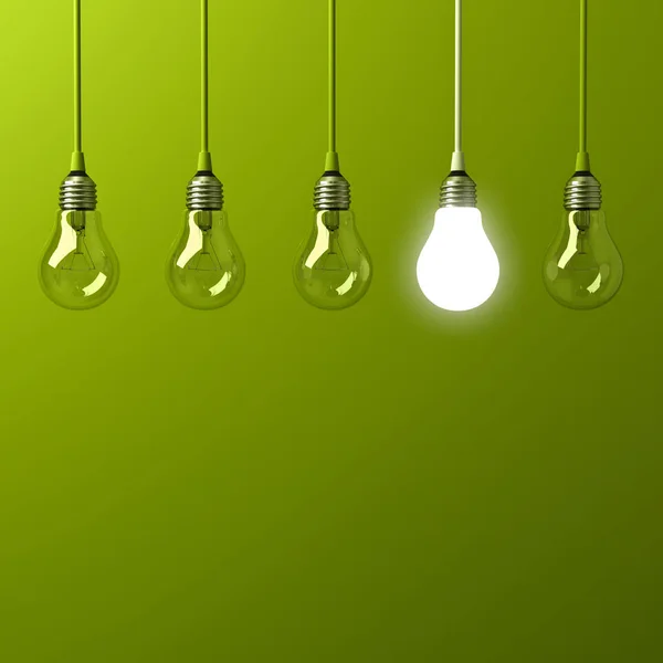 One hanging light bulb glowing different and standing out from unlit incandescent bulbs with reflection on green background , leadership and different business creative idea concept — Stock Photo, Image