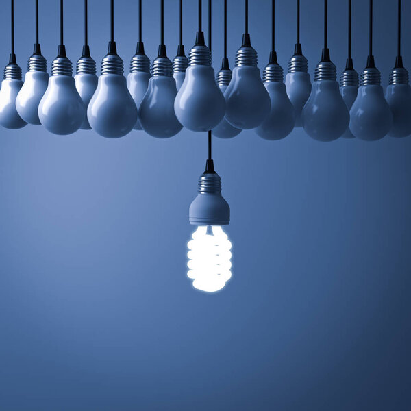 One hanging eco energy saving light bulb glowing and standing out from unlit incandescent bulbs on dark blue background , leadership and different creative idea concept. 3D rendering.