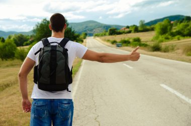 Bir sırt çantası ile bir yolcu üstünde belgili tanımlık yol ve durur standları