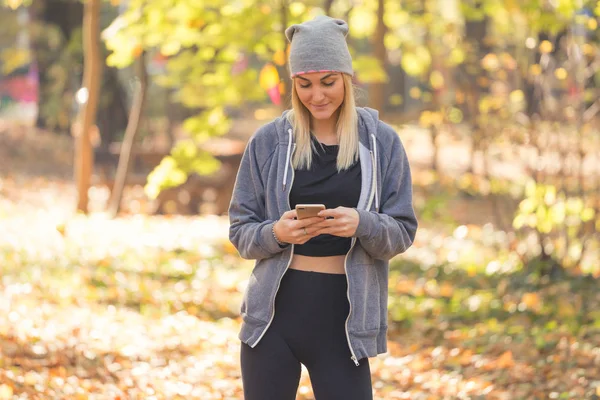 Dziewczyna z telefonu w lesie odczytuje wiadomości — Zdjęcie stockowe