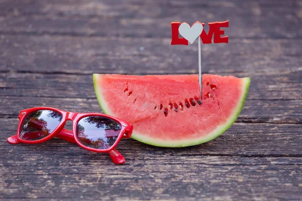 Close up de fatia de melancia com sinal de amor e óculos de sol em ta — Fotografia de Stock