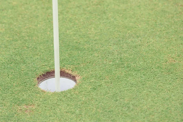 Golf delik bayrak ile yeşil çimenlerin üzerinde kapat — Stok fotoğraf