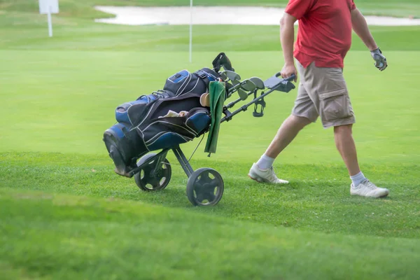 Adam çekme golf çantası trundler üzerinde — Stok fotoğraf