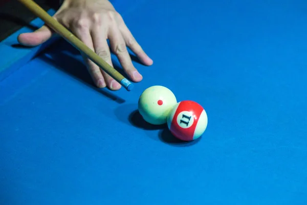 Mão segurando taco de bilhar cue em uma mesa de bilhar pronto para atirar th — Fotografia de Stock