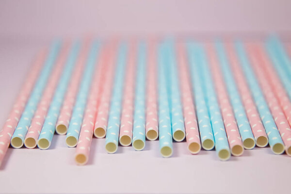 Blue and pink polka dot straws in the pink background 