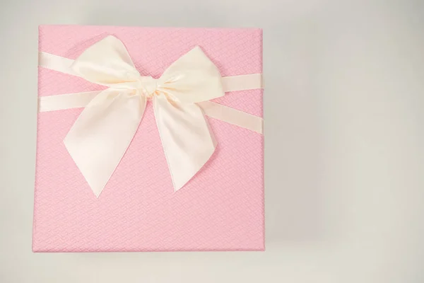 Růžová dárková krabička s kravatou na bílém pozadí. Minimální koncept. — Stock fotografie