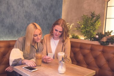 İki genç güzel kızlar kafede oturup kahve içmek ve gitmek