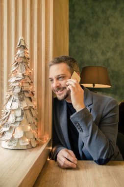 Kafede oturan ve üzerinde cep telefonu, Christm konuşurken işadamı