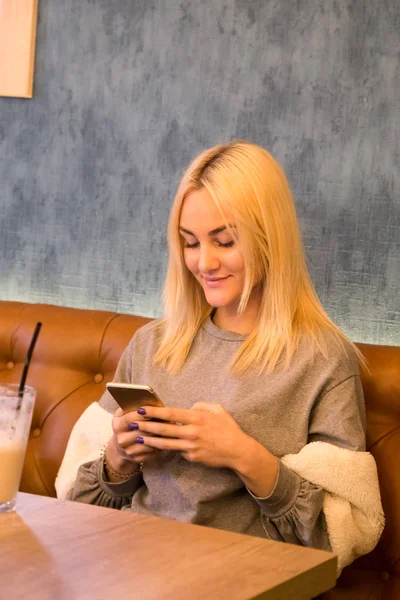 Kafede masada oturan ve mafya kullanarak genç güzel kadın