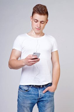 Elinde telefon olan genç bir adam.