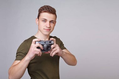 Elinde kamera olan genç bir adam.