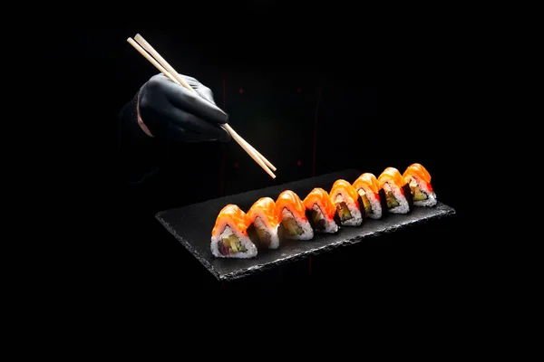 male cook holding sushi in his hands