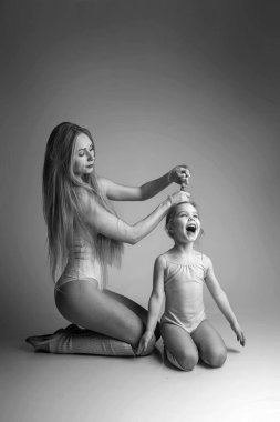 Çocuklu kadın jimnastik yapıyor.