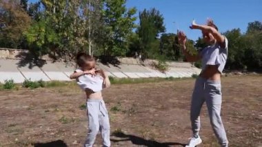 Anne ve kızı dışarıda spor yapıyor.