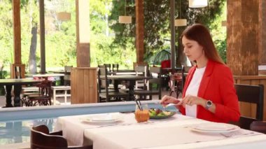 Lokantadaki kız lezzetli yemekler yiyor.