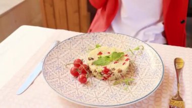 Lokantadaki kız bir tabak yemeğin önünde oturuyor.