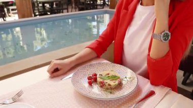 Lokantadaki kız bir tabak yemeğin önünde oturuyor.