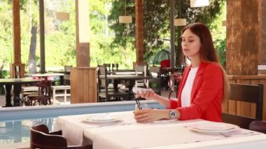 Lokantadaki kız masada oturmuş içki içiyor.