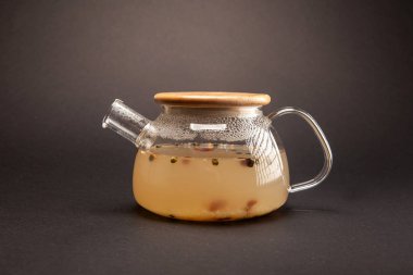 Gri arka planda cam çaydanlıkta demlenmiş sıcak çay.